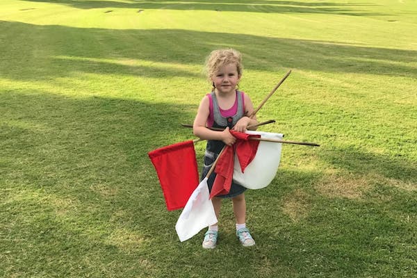 young girl helping by collecting flags